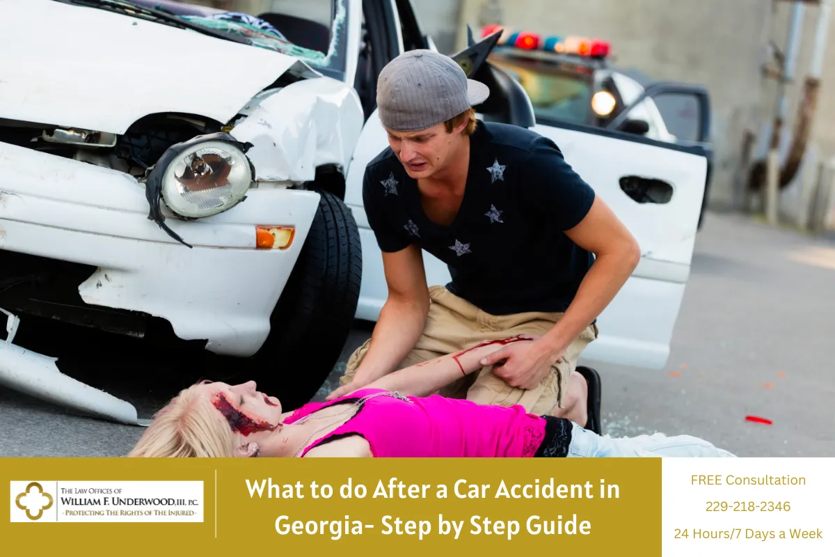 Man assisting injured woman lying on road near damaged white car and police vehicle.