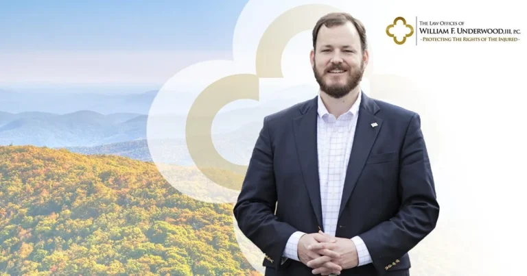 Professional man in dark suit standing with mountains and law office logo in background.