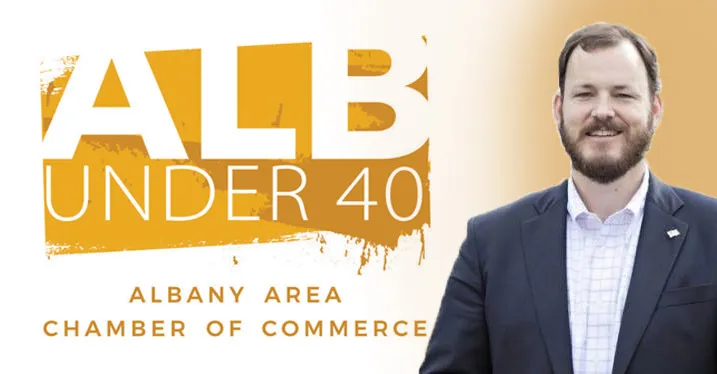 Professional man in suit standing beside "Albany Area Chamber of Commerce" Under 40 graphic.