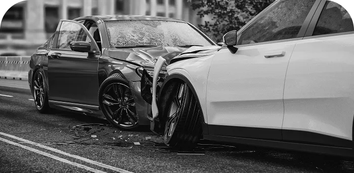 Black and white image of a two-car collision with significant front-end damage.
