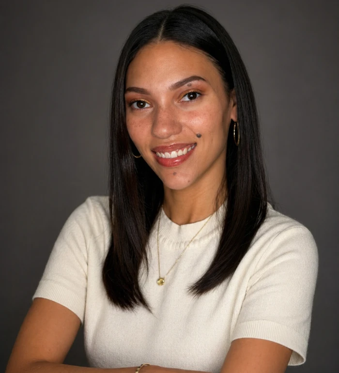 Professional portrait of a smiling woman with long dark hair wearing a white short-sleeve top.