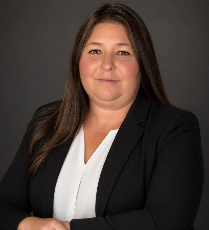 Professional portrait of a woman with long brown hair wearing a black blazer and white blouse.