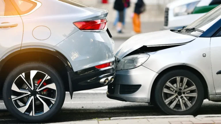 Rear-end collision between a silver SUV and a silver compact car on the street.